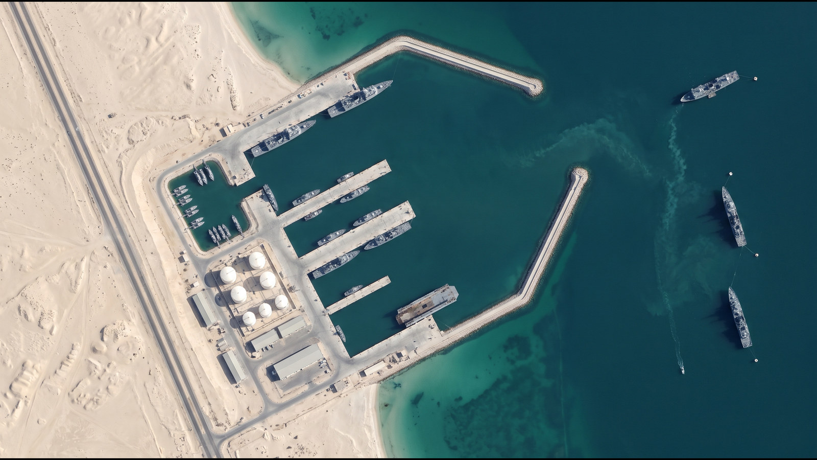 Illustrative: A naval base with vessels alongside and at anchor