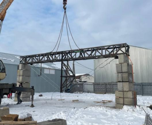 A lattice truss section lifted into place