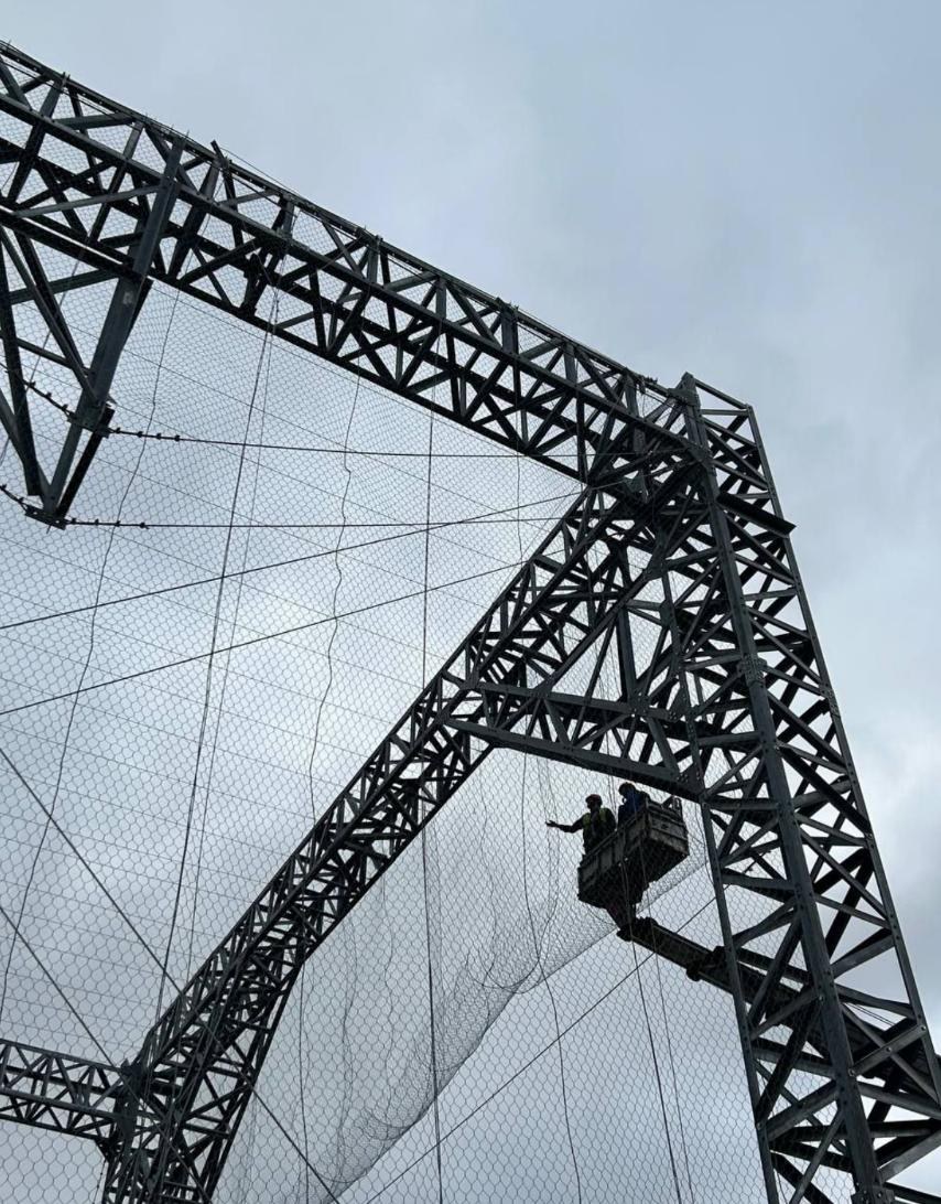 Cable and gabion mesh being installed on a lattice structure
